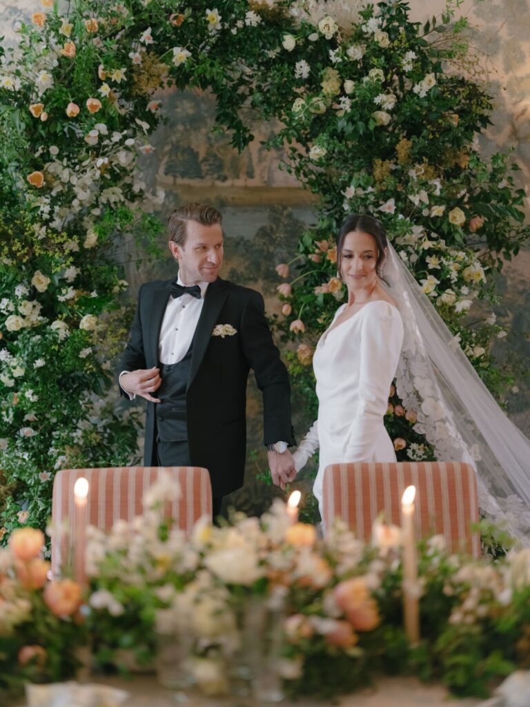 Bride and groom walking behind a wedding table